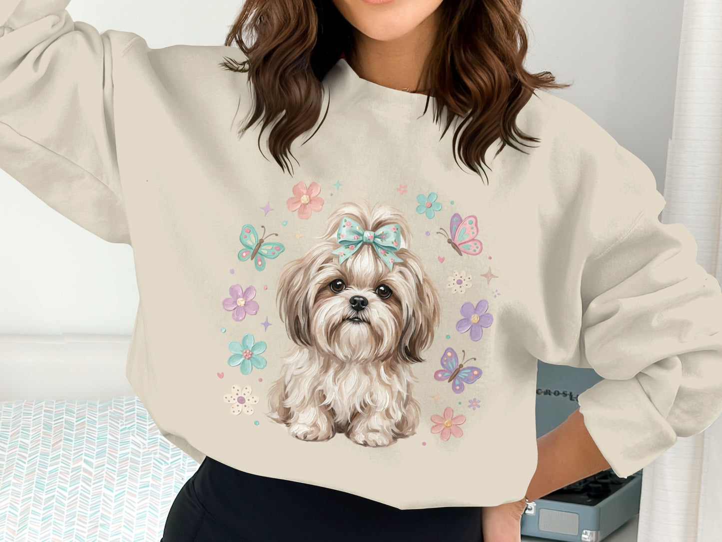 Shih Tzu dog with flowers and butterflies on a light blue sweatshirt.