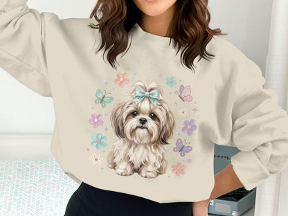 Shih Tzu dog with flowers and butterflies on a light blue sweatshirt.