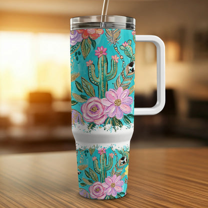 Turquoise tumbler with pink flowers, cacti, and feathers design.