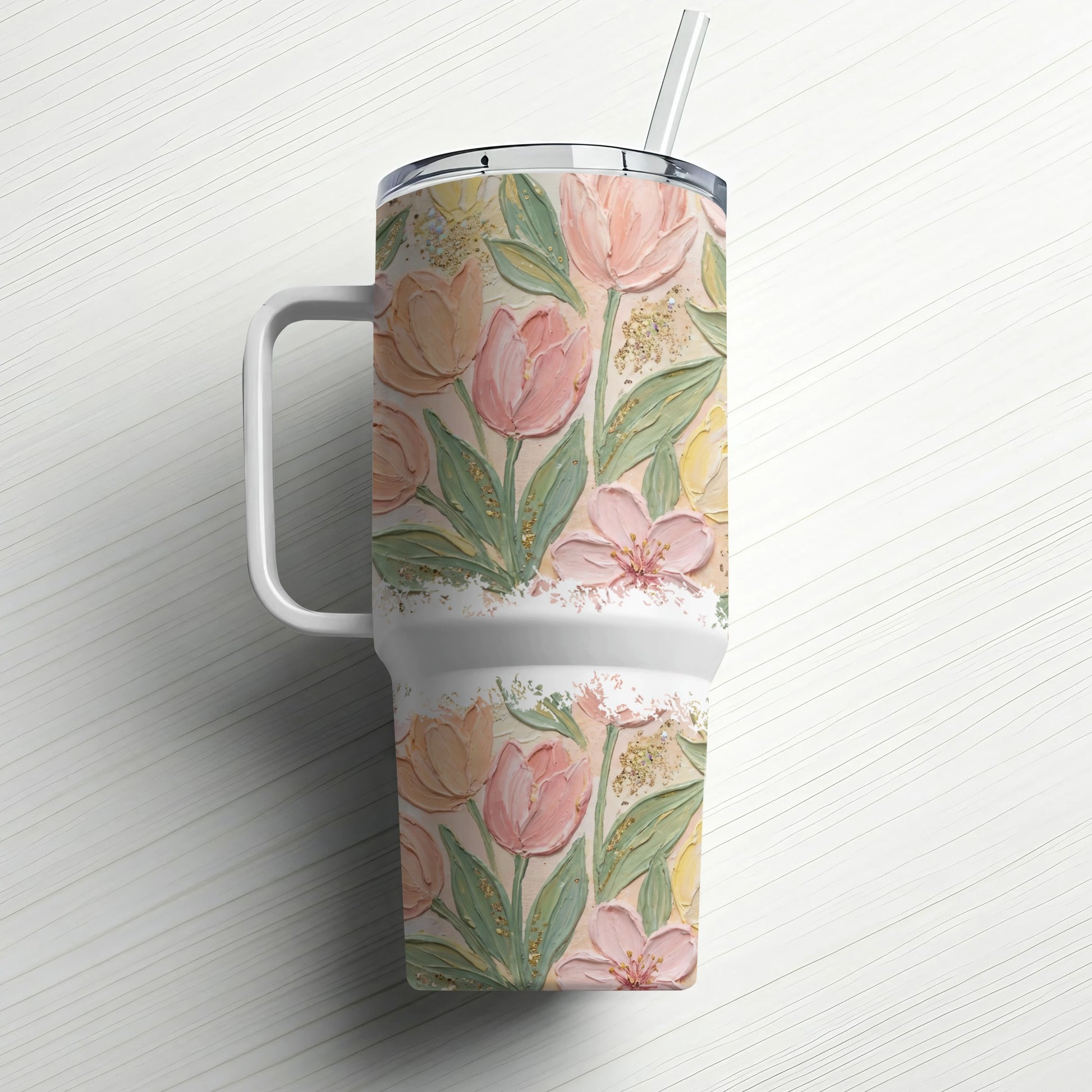 White tumbler with pink and yellow floral design and white handle.