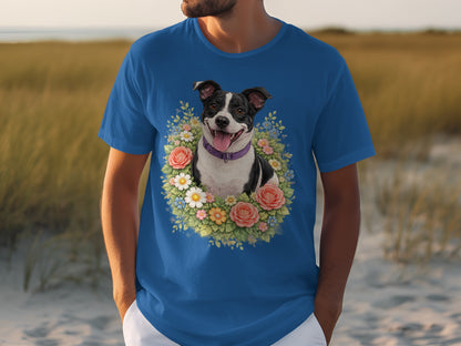 Blue t-shirt with a floral wreath framing a smiling black and white dog.