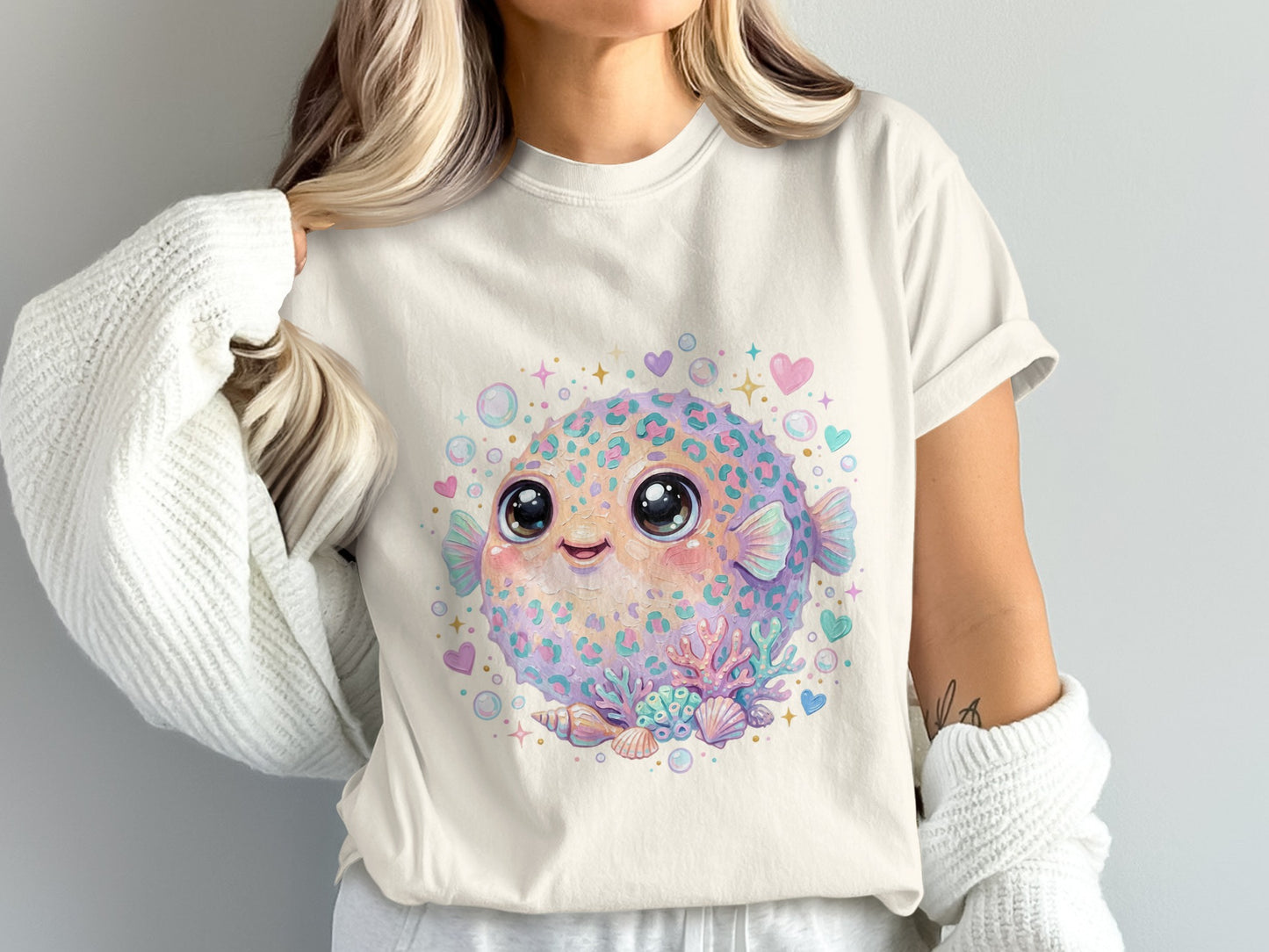 Cute cartoon pufferfish with hearts and seashells on a cream t-shirt.
