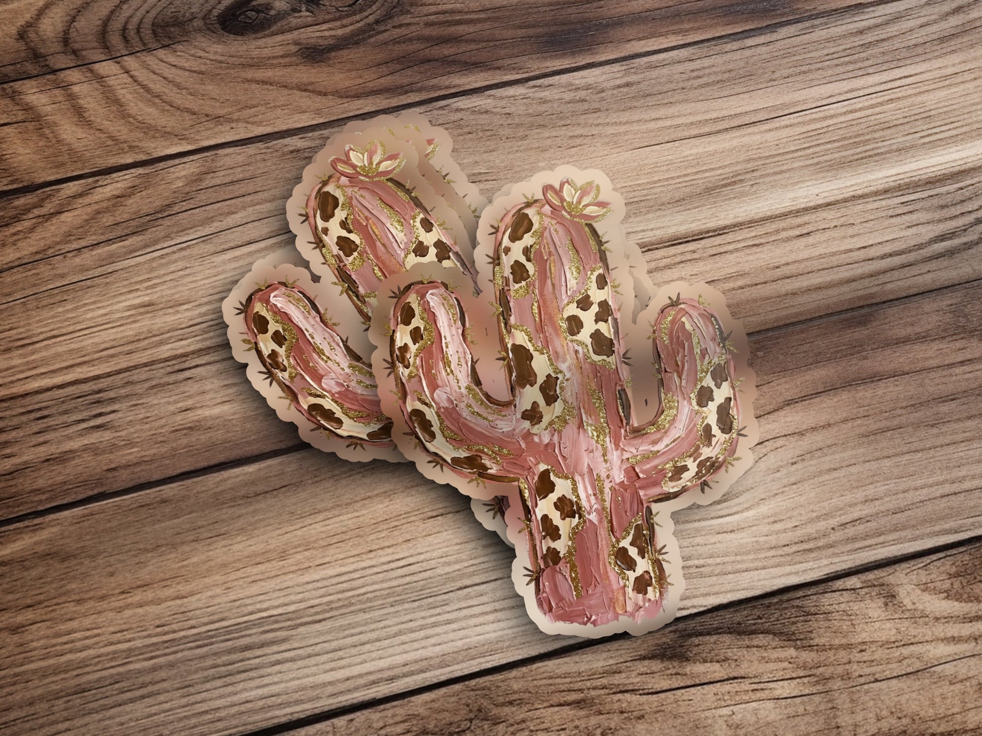 Saguaro cactus stickers with gold accents on a wooden surface.