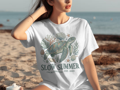 T-shirt with sea turtle, coral, and shells design, "Slow Summer" text.