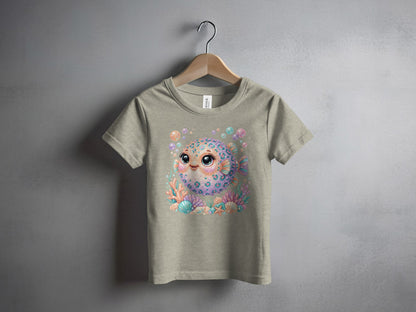 Cartoon pufferfish with colorful scales and bubbles, centered on a tan t-shirt.