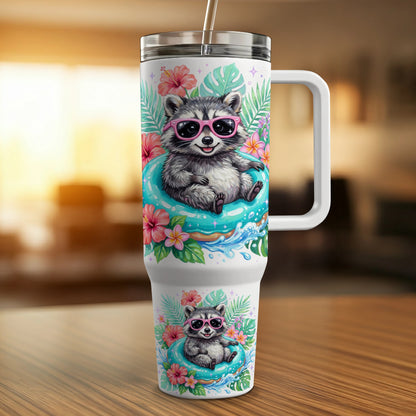 Travel tumbler with sunglasses-wearing raccoons floating in inner tubes, surrounded by tropical flowers.