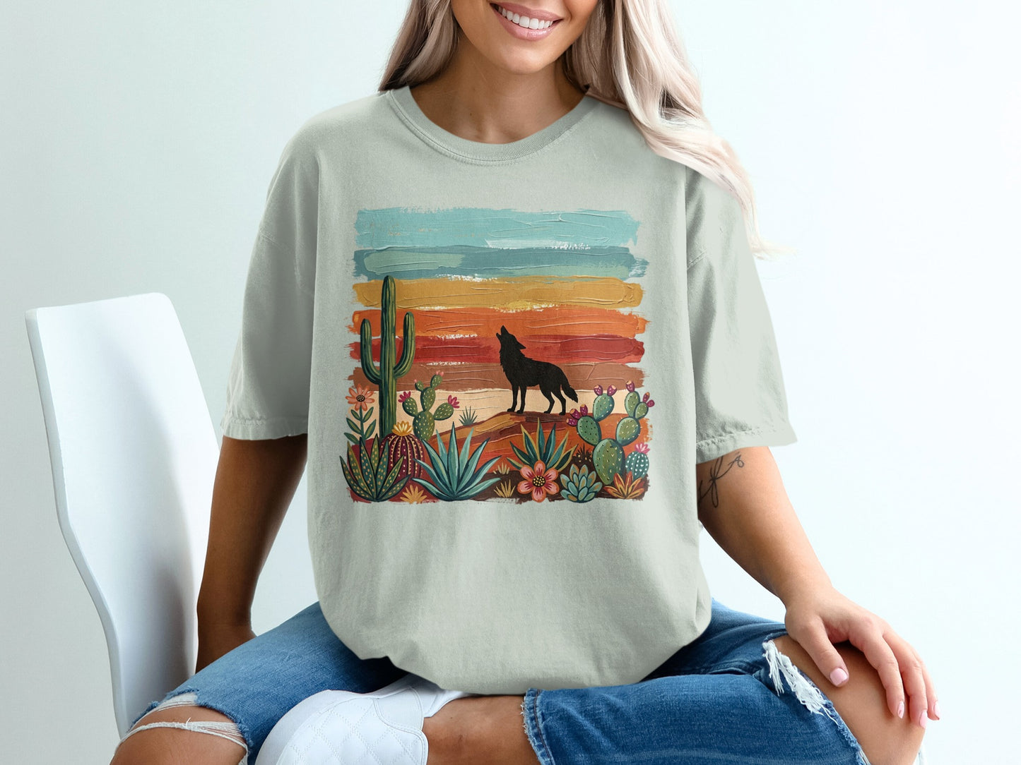 T-shirt with desert scene: howling wolf, cacti, and colorful striped sunset.
