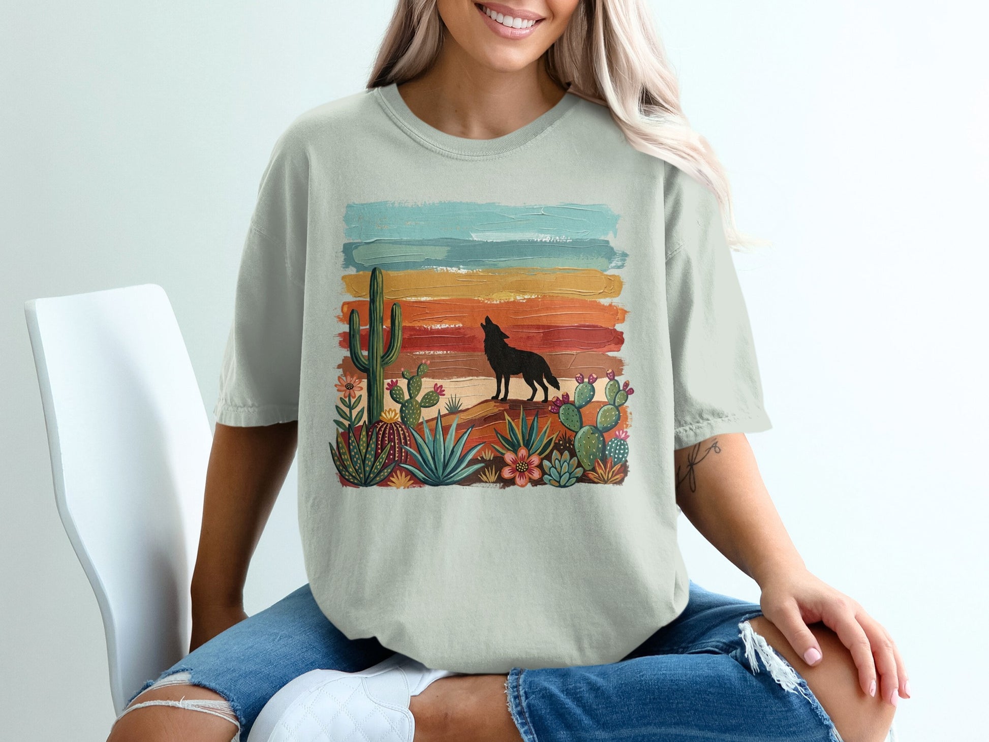 T-shirt with desert scene: howling wolf, cacti, and colorful striped sunset.