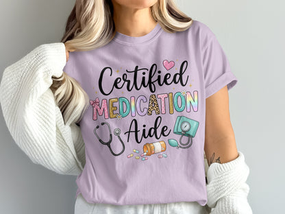 Lilac t-shirt with "Certified Medication Aide" text and medical graphics.