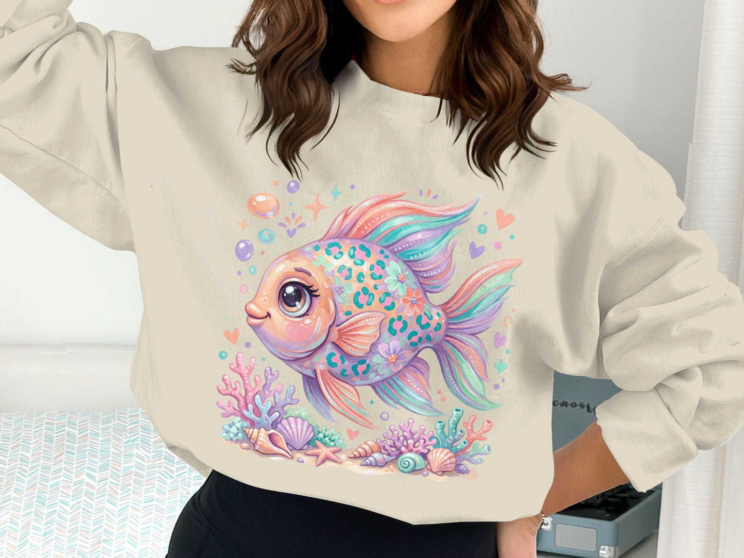 Colorful fish with floral patterns and seashells on a cream sweatshirt.