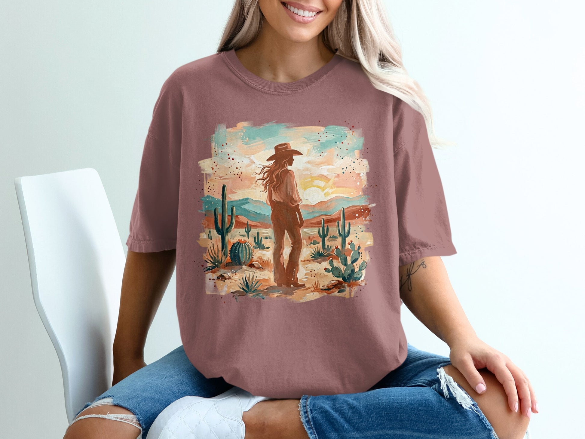 Desert landscape with a woman in a hat on a graphic t-shirt.