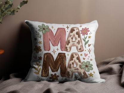 Pillow with "MAMA" in pink and brown cow print, decorated with flowers.