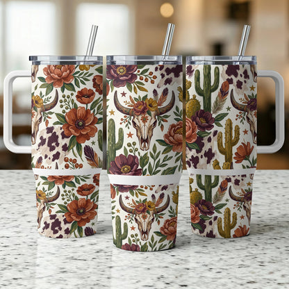 Three insulated tumblers with floral, cow print, and skull designs.