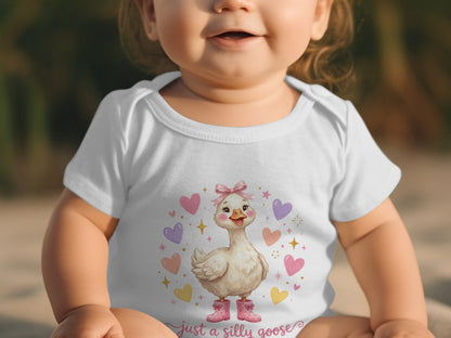 Baby in white bodysuit with a silly goose graphic and pink hearts.