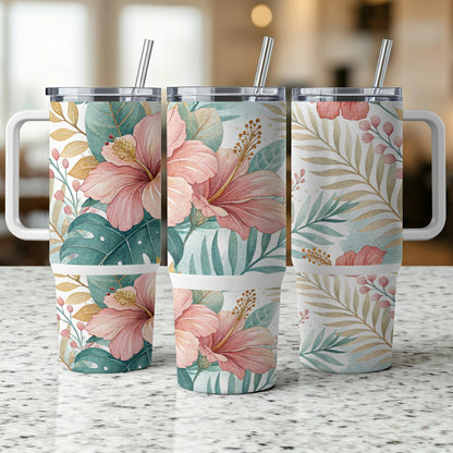 Three tumblers with hibiscus and tropical leaf patterns on a counter.