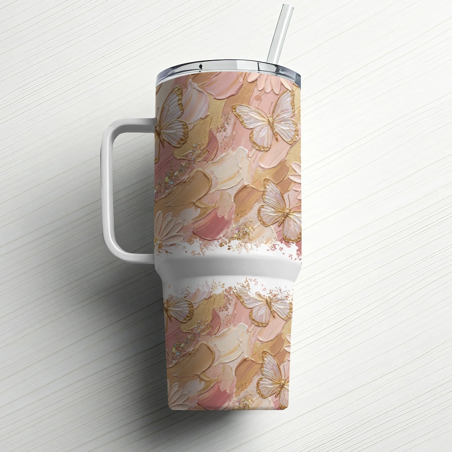 White travel tumbler with blush, cream, and gold butterfly pattern and straw.