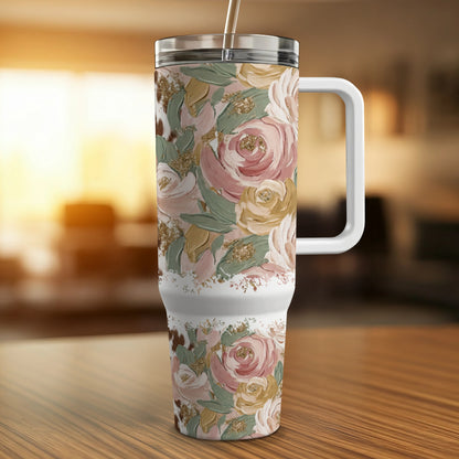 Floral tumbler with handle and straw on a wooden surface.