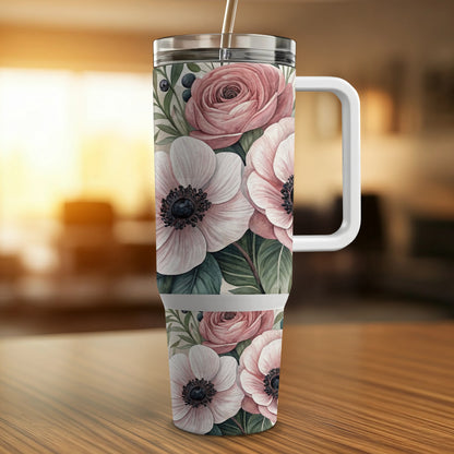 White floral pattern tumbler with handle and straw on wooden table.