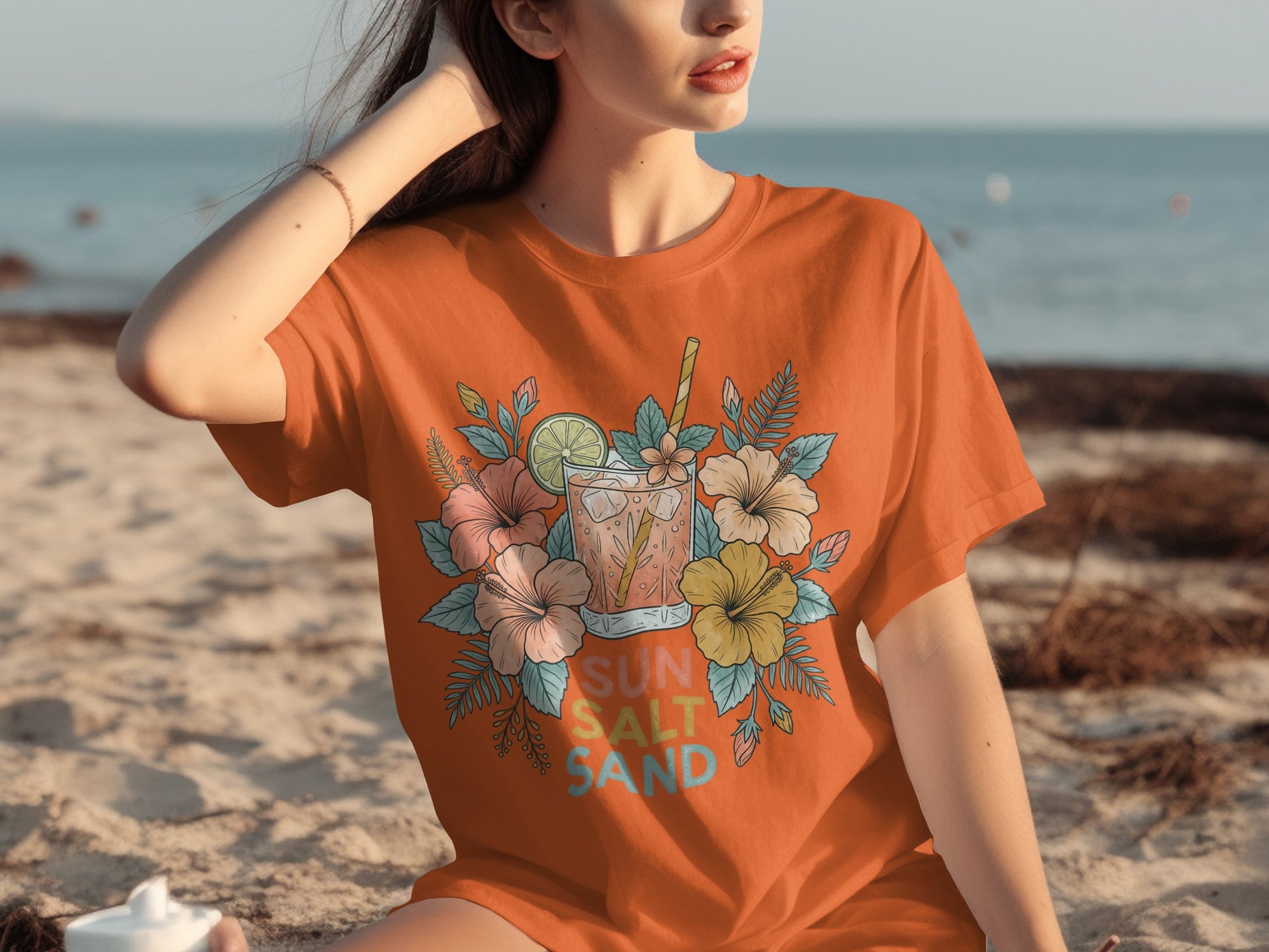 Orange t-shirt with floral design and "SUN SALT SAND" text.