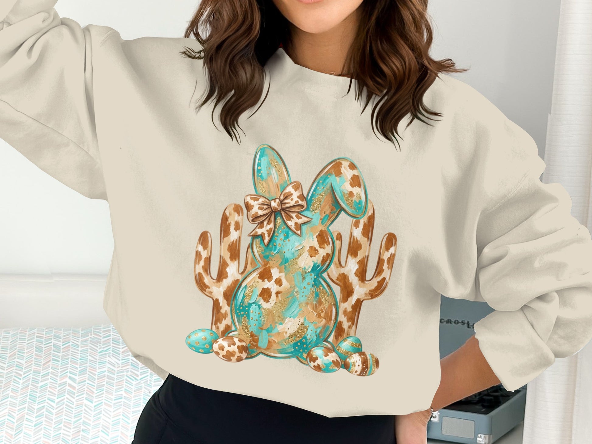 Cream sweatshirt with turquoise and gold speckled Easter bunny graphic and cacti.