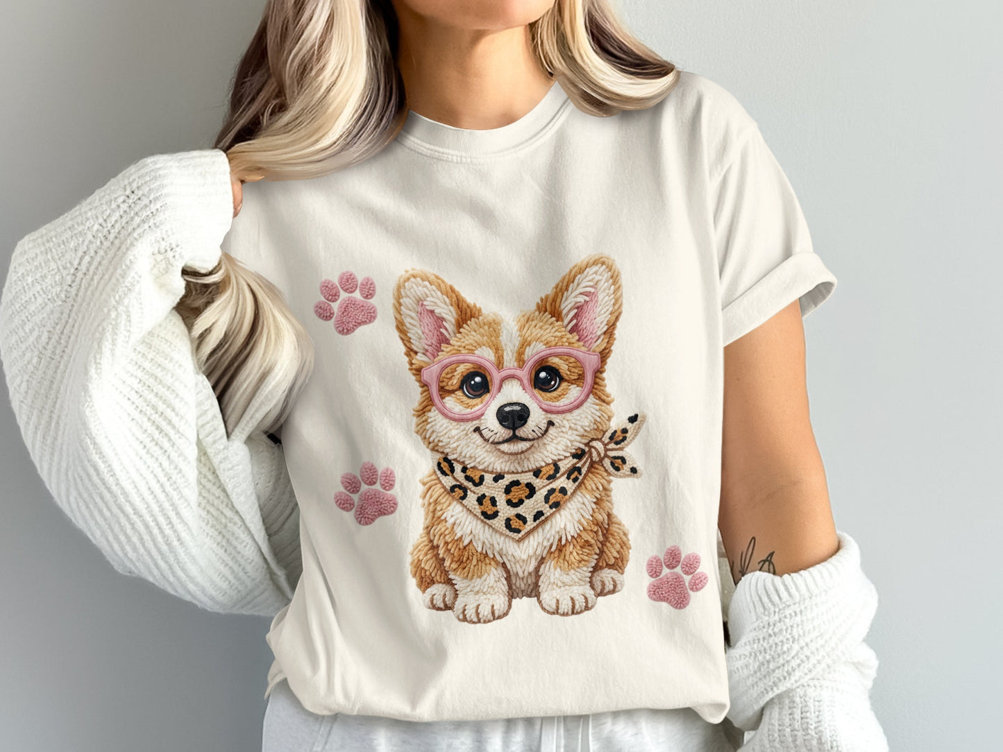Corgi wearing glasses and bandana, with paw prints on a t-shirt.