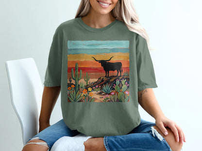 Green t-shirt featuring a desert landscape with a longhorn and colorful painted background.