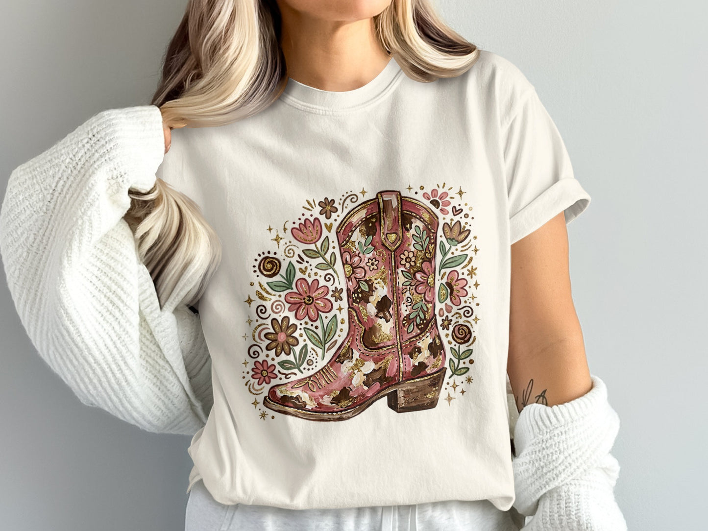 White t-shirt with floral cowboy boot graphic and gold glitter accents.