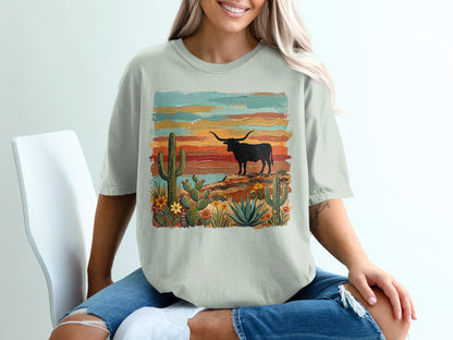 T-shirt with a longhorn steer silhouette against a desert sunset landscape.