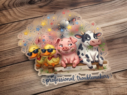 Pig, cow, and ducks on a bench with confetti and "professional troublemakers" text.