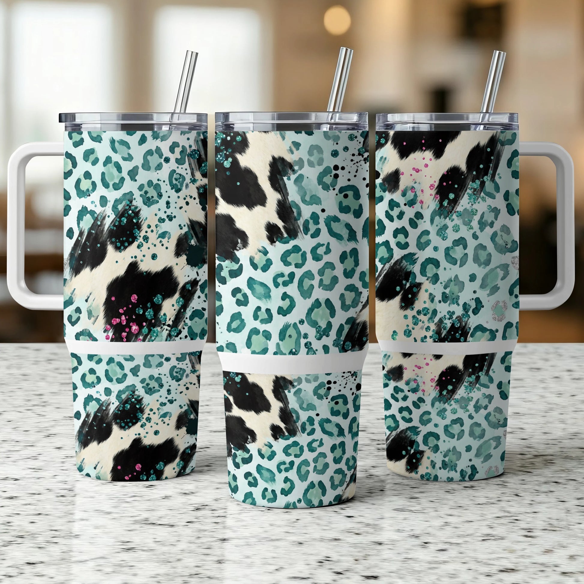 Three tumblers with cow and leopard print patterns and handles.