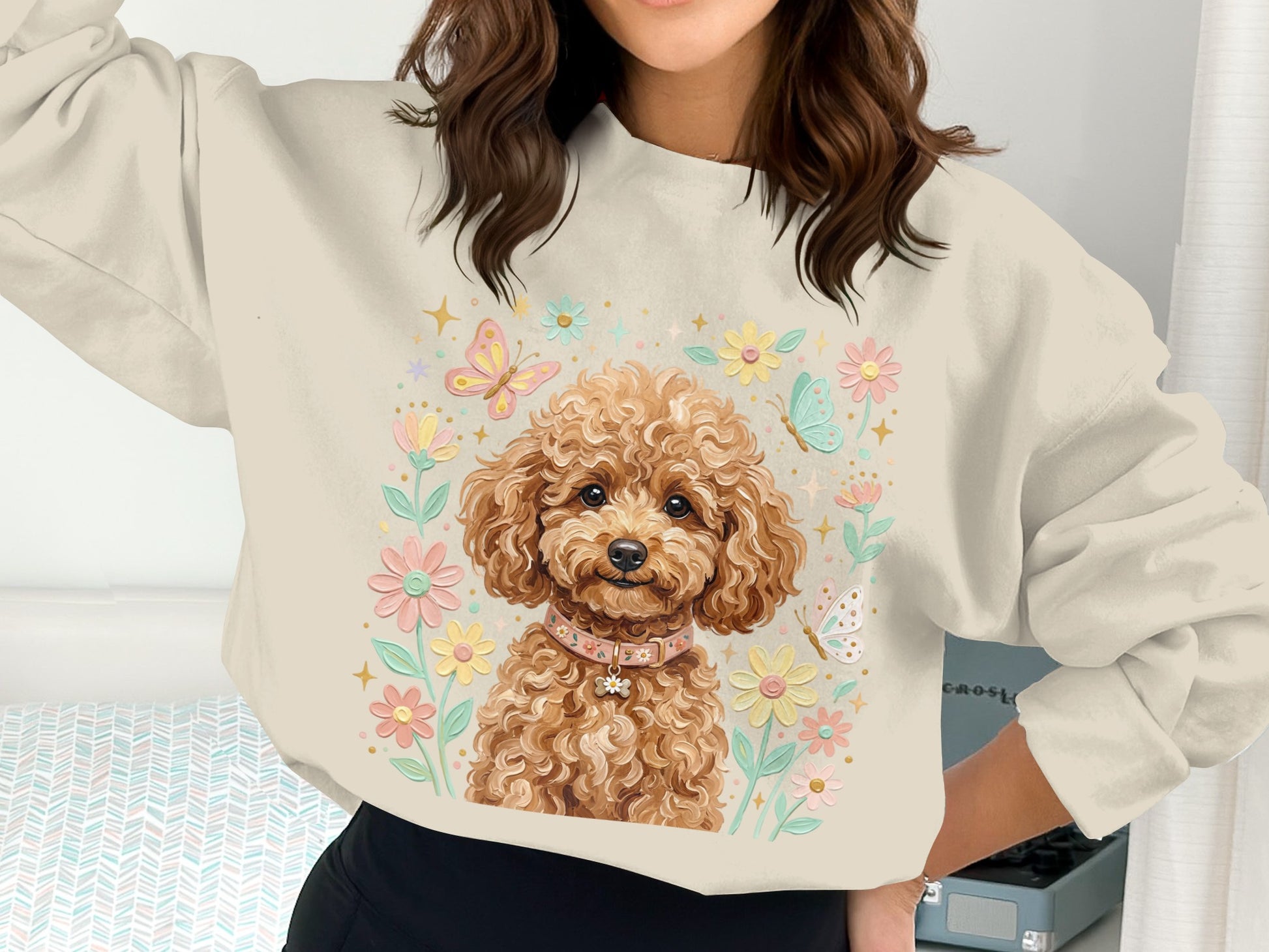 Cream sweatshirt with a poodle surrounded by flowers and butterflies.
