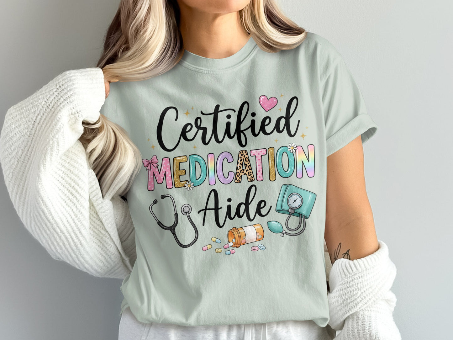 Light blue t-shirt with "Certified Medication Aide" text and medical icons.