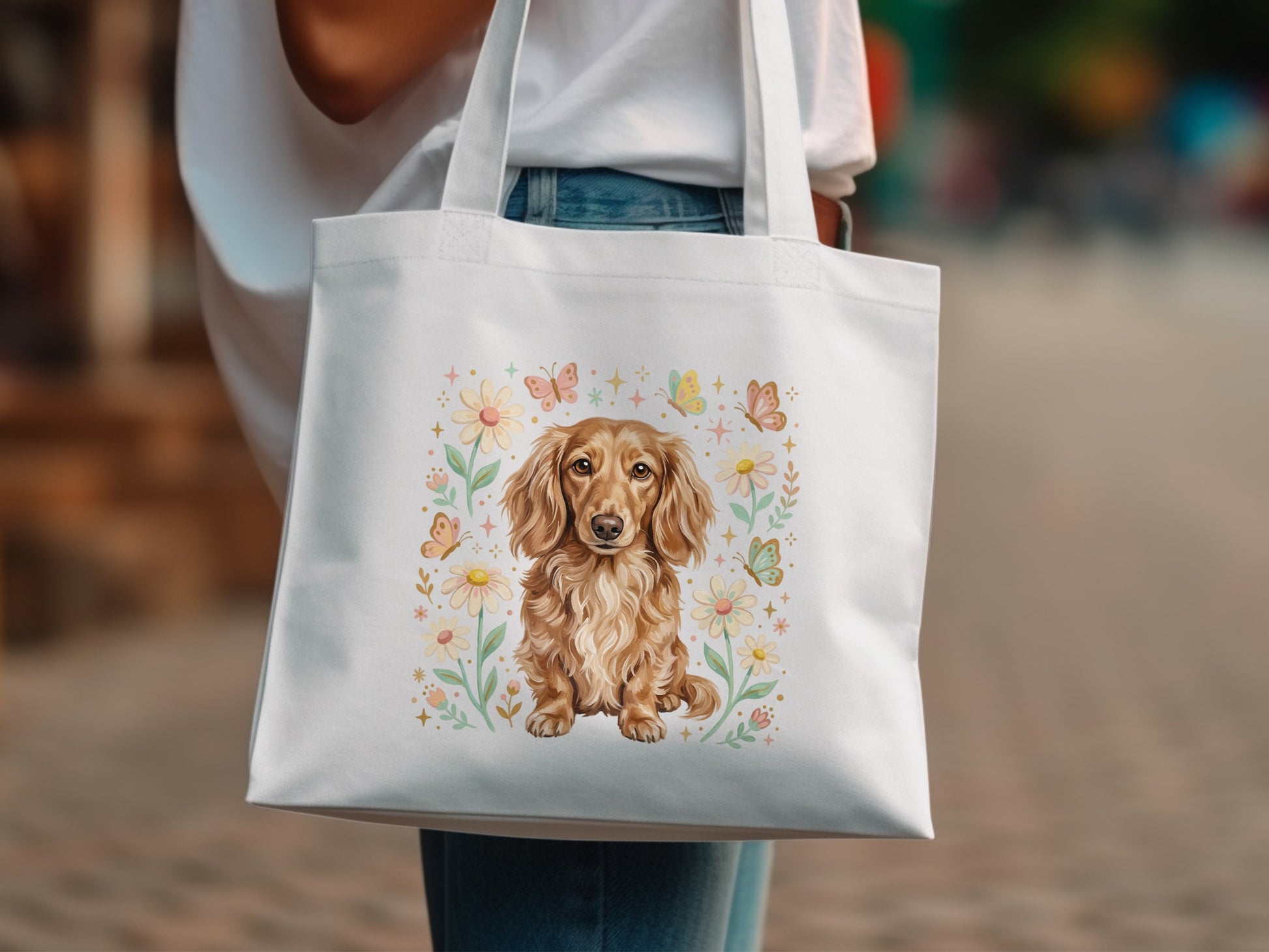 White tote bag featuring a dachshund surrounded by flowers and butterflies.
