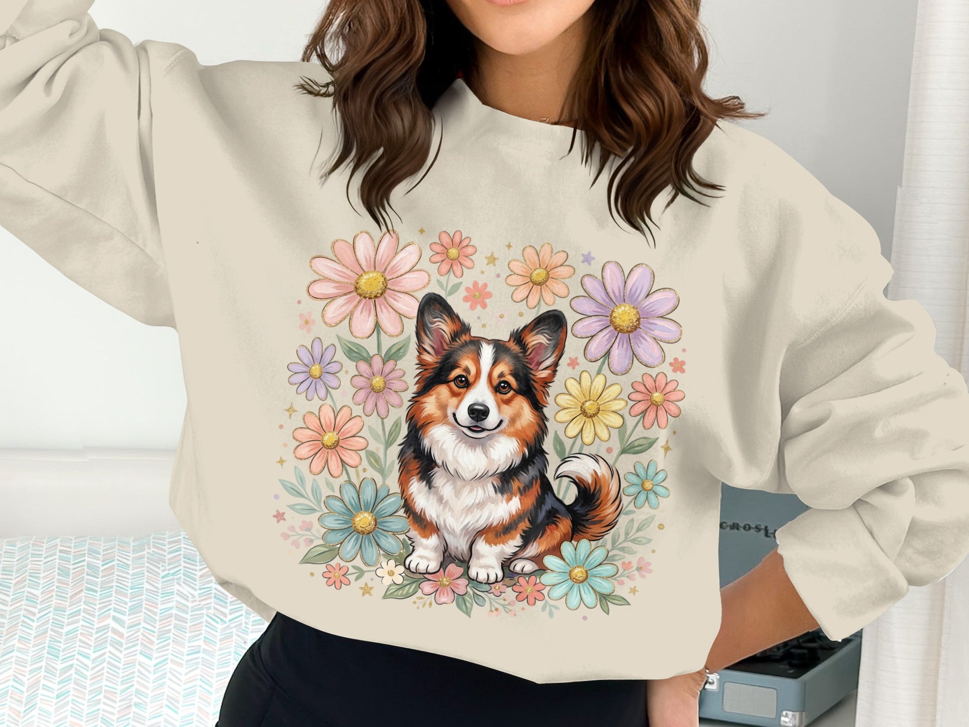 Woman wearing a sweatshirt with a corgi and flowers illustration.