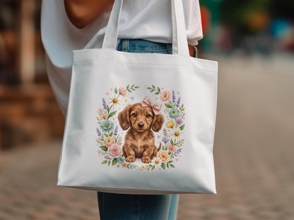 Tote bag with watercolor dachshund illustration surrounded by flowers and a pink bow.