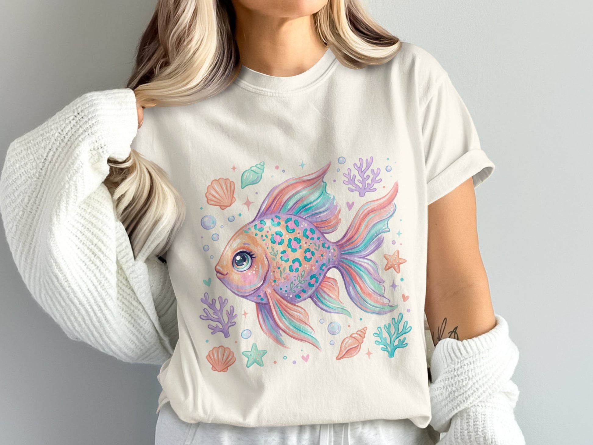 Cream t-shirt with colorful cartoon fish, shells, and coral print.