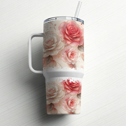 White tumbler with pink and red roses and a straw on a white surface.