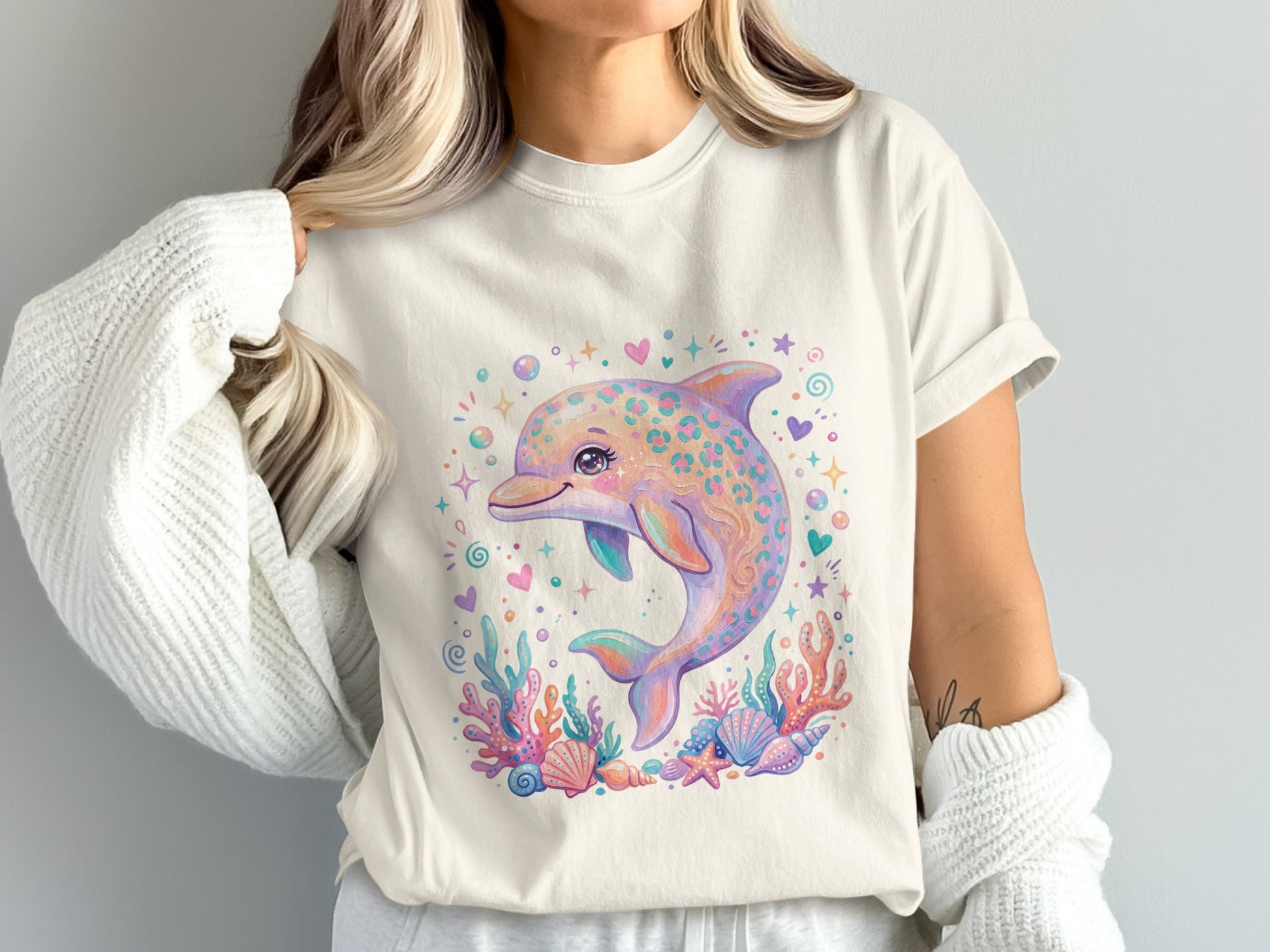 Cream t-shirt with a playful, colorful dolphin and coral reef illustration.