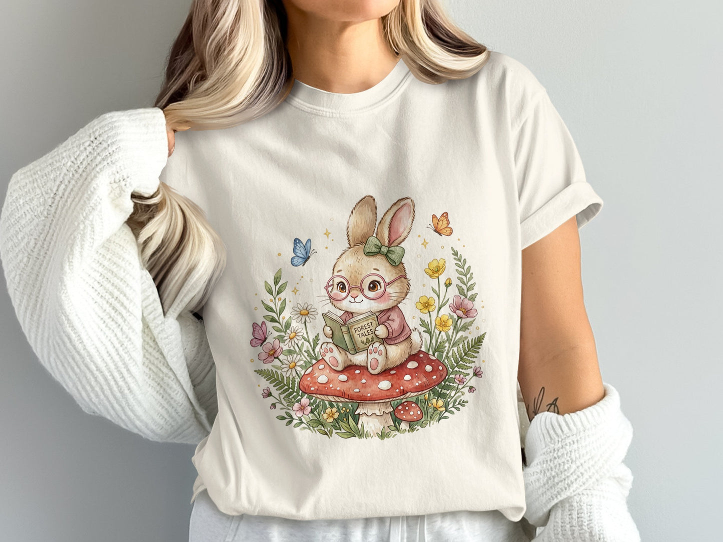 Illustration of a bunny rabbit reading a book on a mushroom, surrounded by flowers and butterflies.